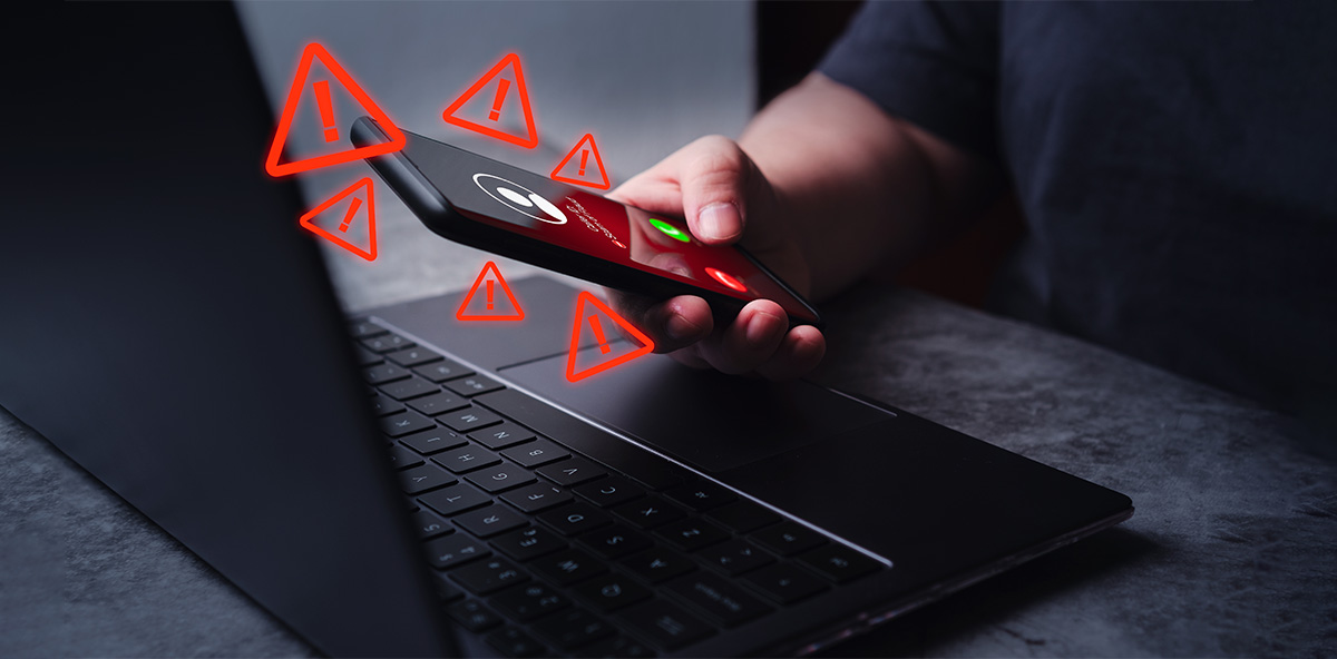 Cybersecurity warning symbols on a phone near a laptop, illustrating endpoint threats that the partner ecosystem strategy aims to block.